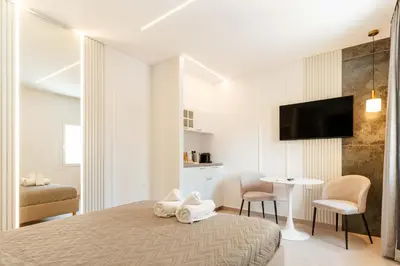 a bedroom with a bed and a table and a tv at The Secret Yard in Larnaka