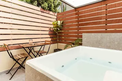 a bath tub in a bathroom with a wooden wall at The Secret Yard in Larnaka