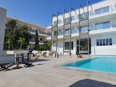 a building with a swimming pool in front of a building at Mythical Sands - Orion in Protaras