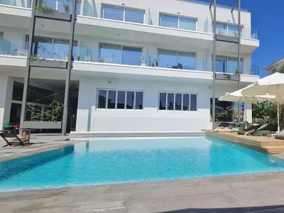 a swimming pool in front of a building at Mythical Sands - Orion in Protaras