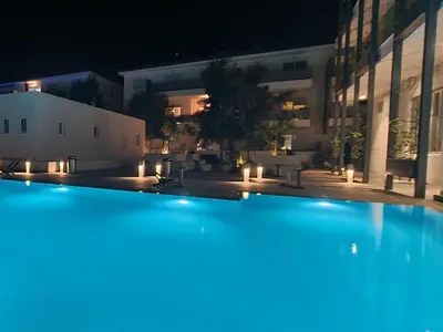 a large swimming pool in front of a building at night at Mythical Sands - Orion in Protaras