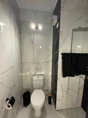 a white bathroom with a toilet and a mirror at Spacious 1 bedroom flat in Foinikoudes! in Larnaka
