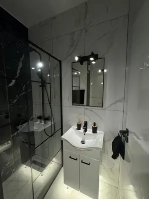 a white bathroom with a sink and a shower at Spacious 1 bedroom flat in Foinikoudes! in Larnaka