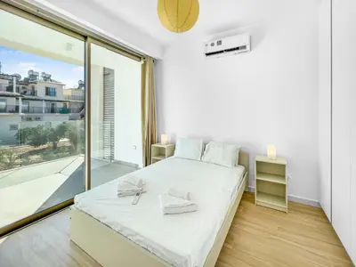 a white bedroom with a bed and a large window at Azure Seaview - Garnet Villa in Protaras