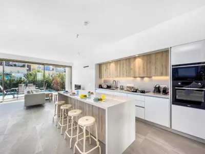 a kitchen with a bar with stools and a counter top at Azure Seaview - Garnet Villa in Protaras