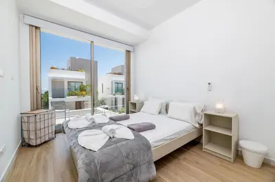 a bedroom with two beds and a large window at Azure Seaview - Ruby Villa in Protaras