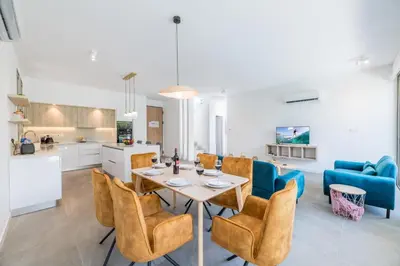 a kitchen and living room with a table and chairs at Azure Seaview - Ruby Villa in Protaras