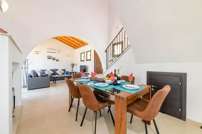 a dining room and living room with a table and chairs at Kymma Villa #12 in Ayia Napa