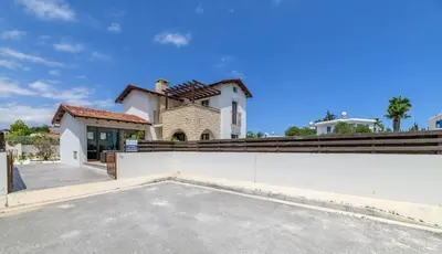 a large white house with a fence in front of it at Kymma Villa #12 in Ayia Napa