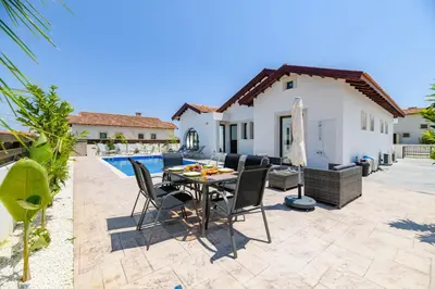 a patio with a table and chairs next to a pool at Kymma Villa #5 in Ayia Napa