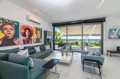 a living room with blue couches and a table at By The Beach - Emerald Seaview Villa in Protaras