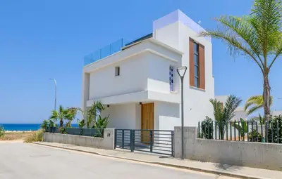 a white house with the ocean in the background at By The Beach - Emerald Seaview Villa in Protaras