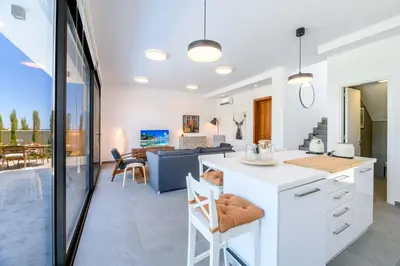 a kitchen and living room with a table and chairs at By The Beach - Sea Pearl Villa in Protaras