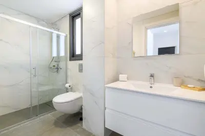 a white bathroom with a sink and a toilet at By The Beach - Sea Pearl Villa in Protaras