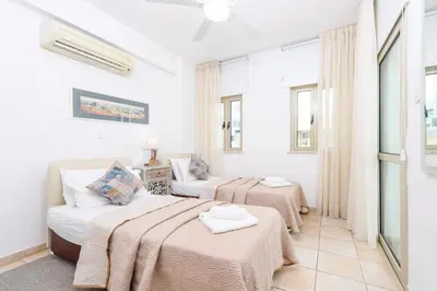 a bedroom with two beds and a couch at Sunrise Bay Villa #2 in Protaras