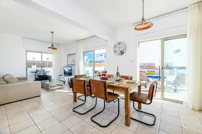a kitchen and living room with a table and chairs at Sunrise Bay Villa #3 in Protaras