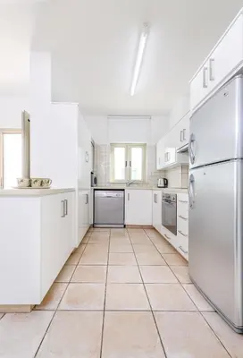 a kitchen with white appliances and a tiled floor at Sunrise Bay Villa #4 in Protaras