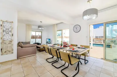 a kitchen and living room with a table and chairs at Sunrise Bay Villa #5 in Protaras