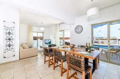 a dining room and living room with a table and chairs at Sunrise Bay Villa #6 in Protaras