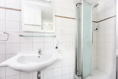 a white bathroom with a sink and a shower at Sunrise Bay Villa #6 in Protaras