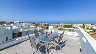 a dining table on a balcony with a view of the ocean at Mylos Lifestyle Seaview Villa #15 in Protaras