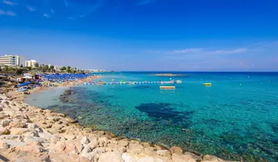 a beach with a group of people in the water at Mylos Lifestyle Seaview Villa #15 in Protaras