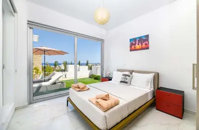 a bedroom with a bed and a large window at Mylos Lifestyle Seaview Villa #37 in Protaras