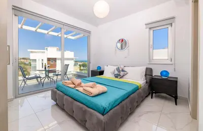 a bedroom with a large bed and a balcony at Mylos Lifestyle Seaview Villa #37 in Protaras