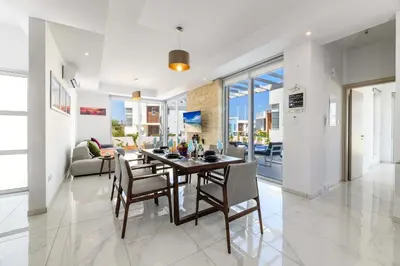 a dining room and living room with a table and chairs at Mylos Lifestyle Seaview Villa #37 in Protaras