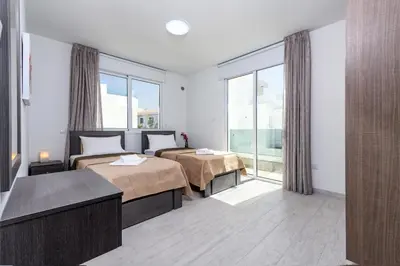 a hotel room with two beds and a large window at Green Bay Villa #14 in Protaras