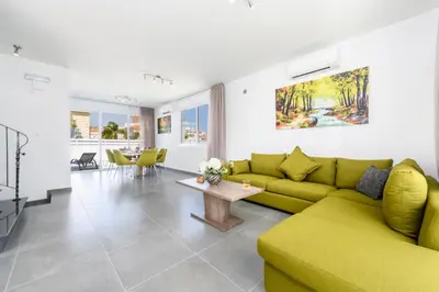 a living room with a green couch and a table at Green Bay Villa #14 in Protaras