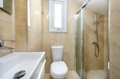 a bathroom with a toilet and a sink and a shower at Green Bay Villa #16 in Protaras