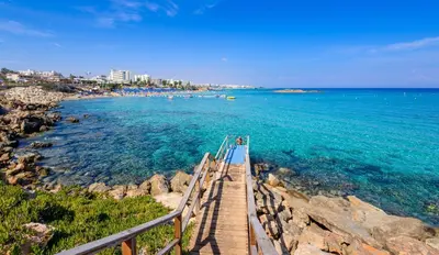 a wooden bridge over the water near a beach at Green Bay Villa #16 in Protaras