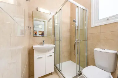 a bathroom with a shower and a toilet and a sink at Green Bay Villa #16 in Protaras