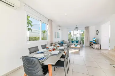 a dining room and living room with a table and chairs at Green Bay Villa #17 in Protaras
