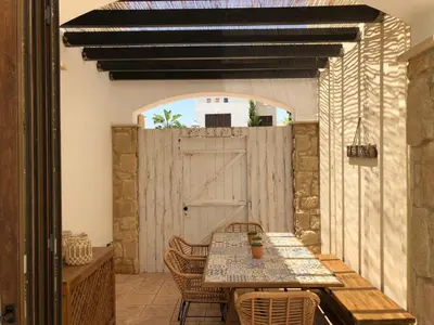 a patio with a table and chairs and a barn door at Villa Greco Mare #6 in Protaras