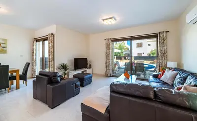 a living room with a leather couch and a table at Villa Greco Mare #20 in Protaras