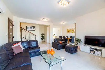 a living room with a leather couch and a tv at Villa Greco Mare #20 in Protaras