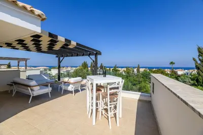 a patio with a table and chairs and an umbrella at Villa Greco Mare #40 in Protaras