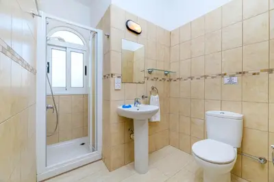 a bathroom with a toilet and a sink and a shower at Villa Clementine in Protaras