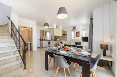 a dining room and kitchen with a table and chairs at Villa Clementine in Protaras