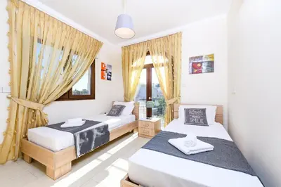 a bedroom with two beds and a window at Hanns Villa in Protaras