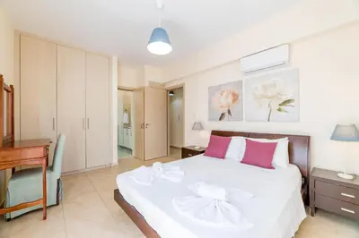 a bedroom with a large white bed with pink pillows at Villa Hannah in Protaras