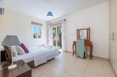 a bedroom with a bed and a desk and a table at Villa Hannah in Protaras
