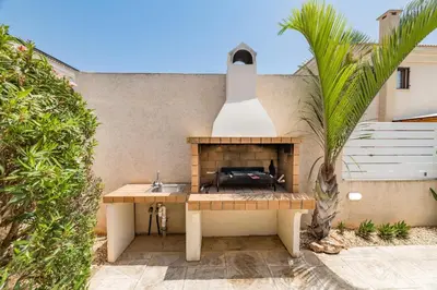 a patio with a fireplace and a palm tree at Villa Hannah in Protaras