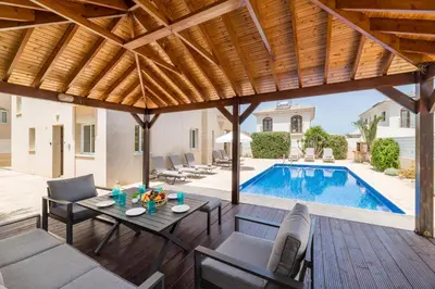 a patio with a table and chairs and a swimming pool at Villa Hannah in Protaras