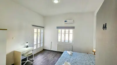 a white room with a bed and a desk at The Lemon Tree Hostel in Larnaka