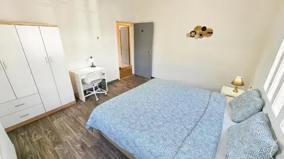 a bedroom with a blue bed and a desk at The Lemon Tree Hostel in Larnaka