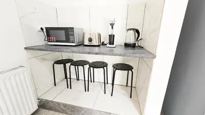 a counter with three stools and a microwave at The Lemon Tree Hostel in Larnaka
