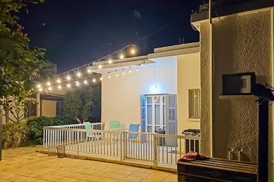 a house with a balcony at night with lights at The Lemon Tree Hostel in Larnaka